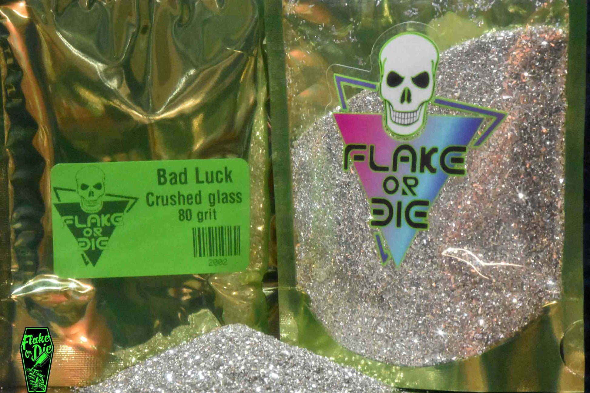 Macro photography product shot of silver glass particles in a clear window foil package with company logo.