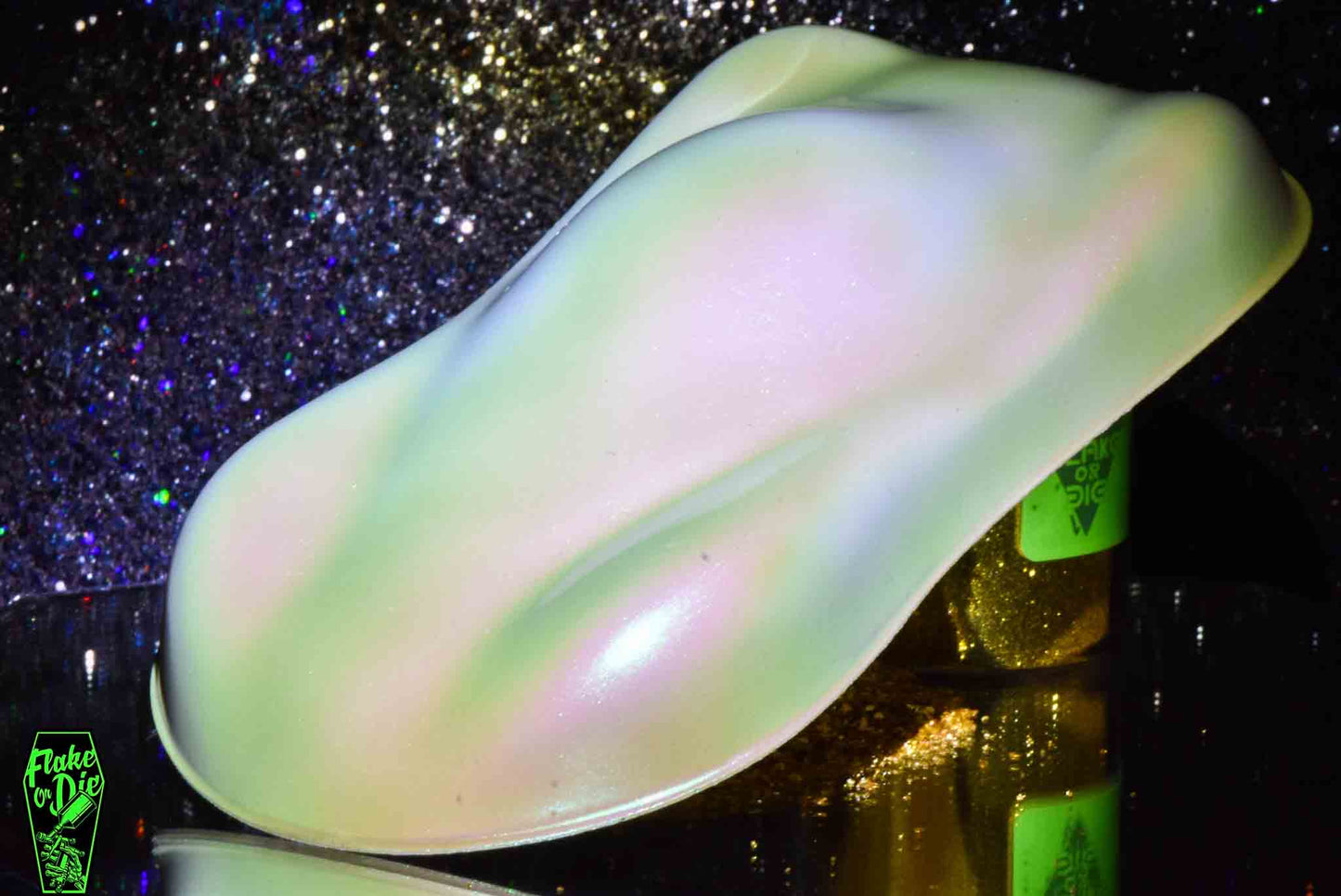 Macro photography of a car like speed shape painted with white colorshift pearl pigment. Lighting contrasts of white, purple, pink and green on the curves of the shape. Mirrored platform and complementary background of silver bokeh.