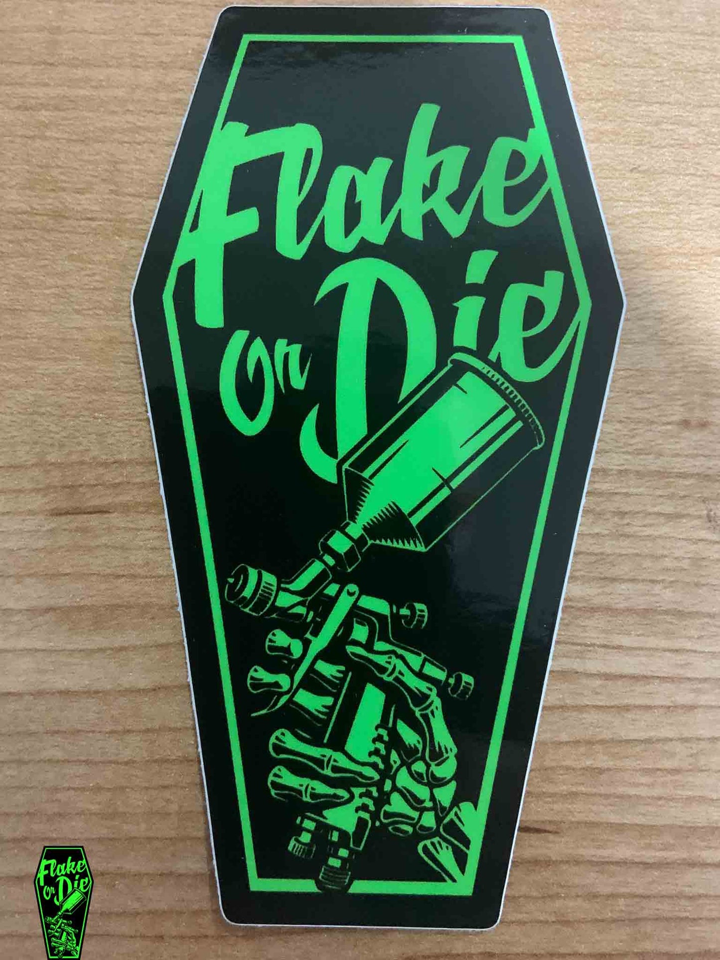 Green and Black version of the Flake Or Die coffin logo. The sticker is 4" high by 2" wide.