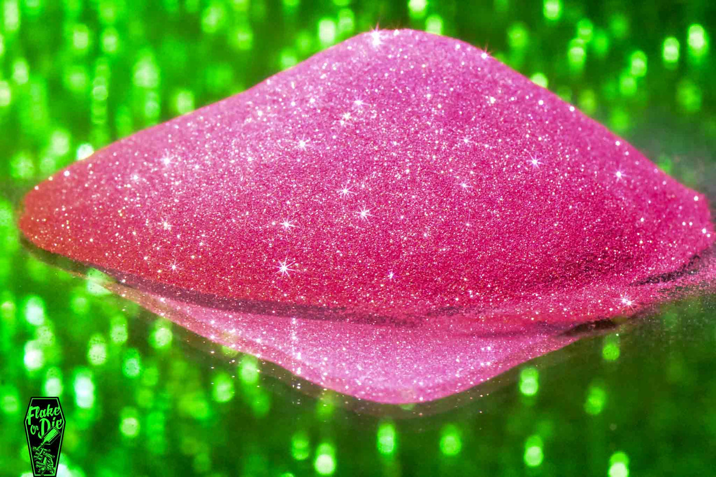 Macro photography of a small pile of red metal flake particles. Distinct glitter flares on the metal flake and a background of green bokeh.