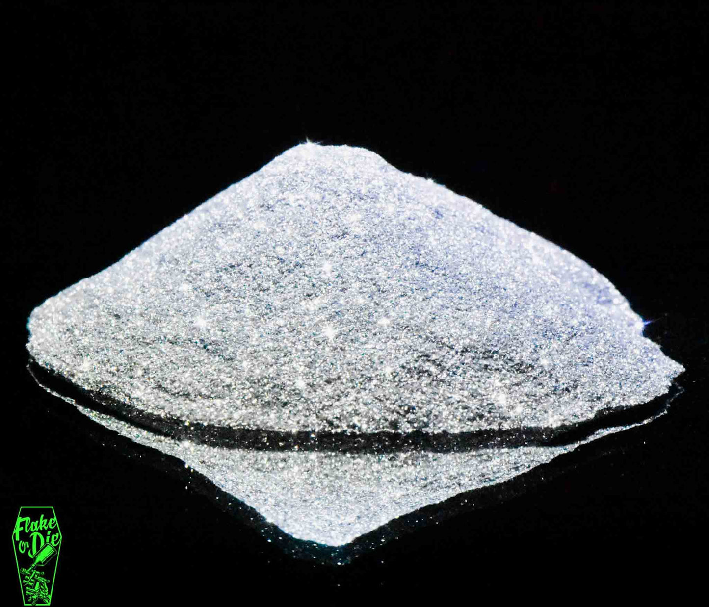 Macro photography of a small pile of silver metal flake particles. Distinct glitter flares on the metal flake and a stark black background.