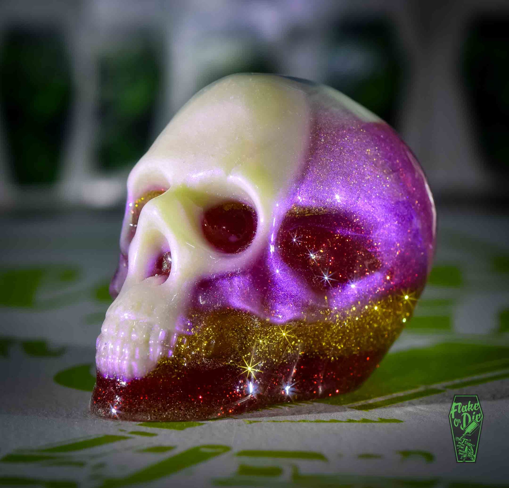 Skull cast with metal flake and pearl pigments in clear liquid plastic.