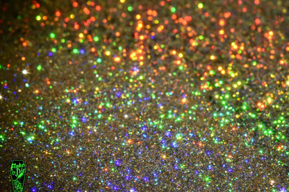 Macro photography of blended gold holographic metal flake particles. Distinct glitter flares of gold, purple, green and orange on the metal flake.