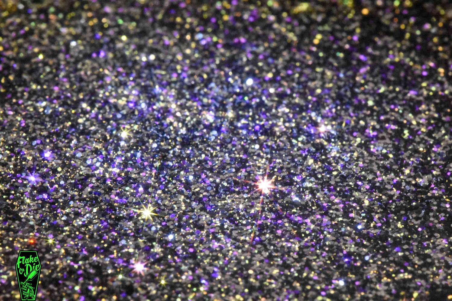 Macro photography of a small pile of blended black, gold and purple metal flake particles.