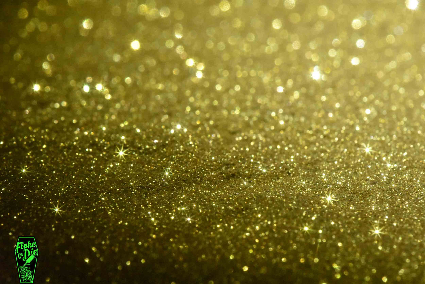 Macro photography of a small pile of gold metal flake particles. Distinct glitter flares on the metal flake.