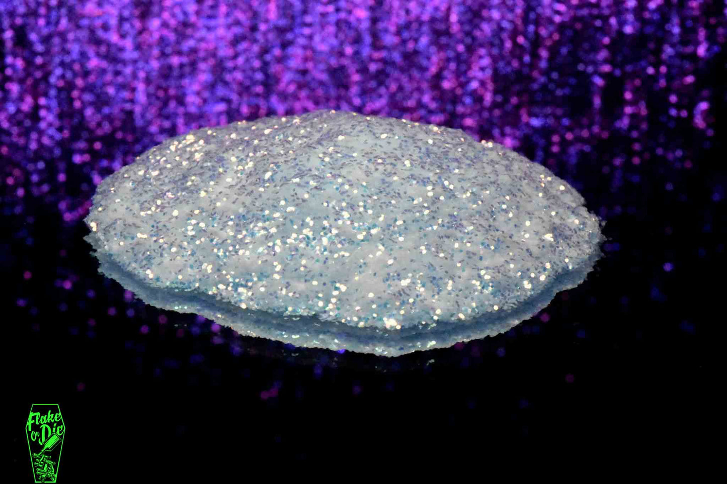 Macro photography of a small pile of white iridescent metal flake particles. Distinct glitter flares on the metal flake and a complementary background with purple bokeh.