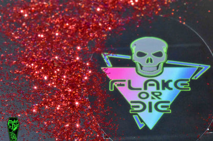 Flake or Die product photography of red hex cut metal flake spread out over logo sticker.