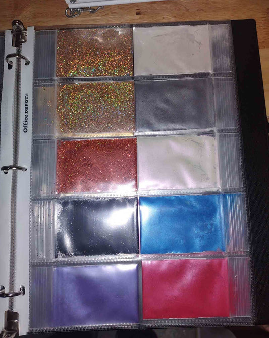 10 color samples from Flake or Die. Showing holographic and black metal flakes, with red, blue, grey and white pearl pigment powders,